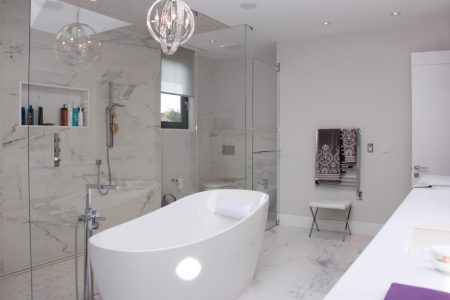 Toronto bathroom renovation by Milman, featuring a seamless ensemble of white bathroom tiles, a chic vanity, and top-tier fittings