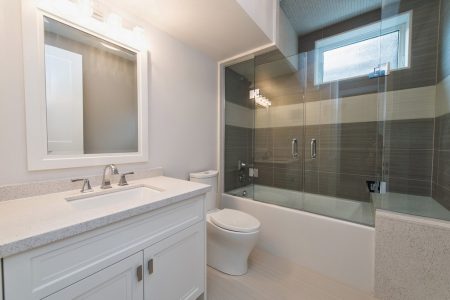 Toronto bathroom renovation project featuring white faucet , bathtub, backsplash and vanity