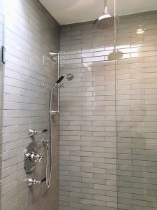 Toronto Bathroom renovation by Milman Design build features white tiles and walk in shower with glass enclosure