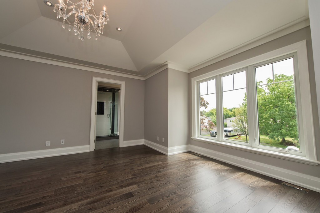 Home renovation project by Milman Design Build, Toronto Home Renovation contractors featuring living room with Large custom windows, wooden floorings, chandelier, Paint job and high celling's