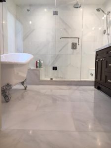 This image showcases a renovated bathroom in an Aurora residence, skillfully redesigned by Milman Design Build, complete with a bathtub, a distinct shower area, and impeccably clean flooring