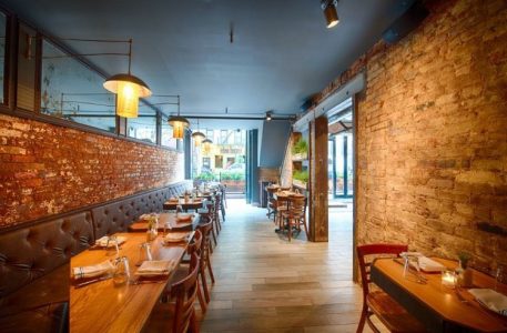 Toronto restaurant Timna got renovated with features like a long hallway decorated chandelier dn others by Milman Design Build.