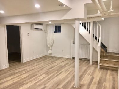 Explore Milman Design Build's Triplex basement reno: hardwood floors, staircase, and a blank canvas.