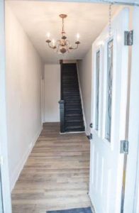 Triplex conversion hallway with door and staircase by Milman Design Build Toronto.